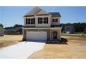 Charming two-story home features a stone accent, a two-car garage and a manicured lawn at 154 Nectar Ln, Bunnlevel, NC 28323