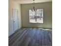 Dining area with wood-look flooring, a modern chandelier, and a window overlooking the backyard at 4955 (Lot 1) Ray Rd, Spring Lake, NC 28390