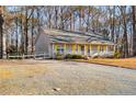 Simple gray house with yellow shutters and gravel driveway at 505 Hiking Trl, Benson, NC 27504