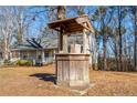 Rustic wooden well with bucket in front of house at 505 Hiking Trl, Benson, NC 27504