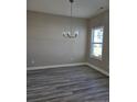 Minimalist dining area with hardwood floors, a decorative chandelier, and natural lighting at 102 Onslow Ct, Spring Lake, NC 28390