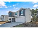 Two-story house with gray and blue siding, a two-car garage, and a landscaped yard at 299 Hallow Oak St, Spring Lake, NC 28390