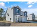 Two-story house with gray and blue siding, a two-car garage, and a landscaped yard at 299 Hallow Oak St, Spring Lake, NC 28390