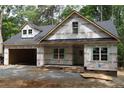 New construction home with a two-car garage showcasing modern architectural design and an unfinished yard at 2194 Cleveland Cir, Sanford, NC 27332