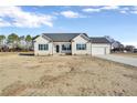 Newly built one-story house featuring beige vinyl siding, gray roof and a two-car garage at 52 Roll Tide Ct, Angier, NC 27501