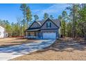 Inviting gray two-story home featuring black accents and a convenient two-car garage in a serene setting at 6967 Old Jefferson Davis Hwy, Cameron, NC 28326