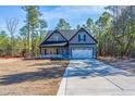 Beautiful gray two-story home with a two-car garage, surrounded by mature trees and lush landscaping at 6967 Old Jefferson Davis Hwy, Cameron, NC 28326