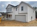 A two story home with white siding, a covered porch, an attached two car garage on a cloudy day at 318 Rocking Horse Ln, Sanford, NC 27332