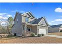 Two-story house with gray siding, stone accents, and a two-car garage at 886 Juno Dr, Broadway, NC 27505