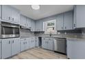 Renovated kitchen featuring light blue cabinets, granite countertops, and stainless steel appliances at 205 N Layton Ave, Dunn, NC 28334