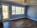 Light blue living room with wood-look floors and window at 2712 Cameron Dr, Sanford, NC 27332