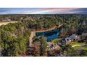 Expansive aerial view of the wooded property featuring a tranquil lake and beautiful homes at 2648 Buckingham Dr, Sanford, NC 27330