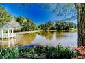Scenic view of a tranquil lake reflecting the surrounding trees and a charming gazebo at 2648 Buckingham Dr, Sanford, NC 27330