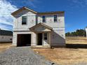 New construction home featuring an unfinished exterior, showcasing the framework with an attached garage and covered entry at 313 Greenbay St, Lillington, NC 27546