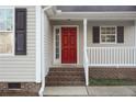 Red front door entryway with brick steps at 357 Juno Dr, Broadway, NC 27505