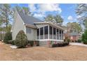 Back exterior view showcasing the screened porch and well-maintained lawn at 60 Rolling Pines Dr, Spring Lake, NC 28390