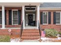 Close-up of a brick home's welcoming front porch with columns and seasonal decorations at 60 Rolling Pines Dr, Spring Lake, NC 28390