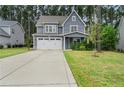 Two-story gray house with white garage door and landscaping at 165 Timber Skip Dr, Spring Lake, NC 28390