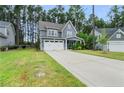 Two-story gray house with white garage doors and manicured lawn at 165 Timber Skip Dr, Spring Lake, NC 28390