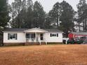 Mobile home with yard, cars, and outbuilding at 192 Washington Ln, Cameron, NC 28326