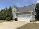 Three-car garage with a long driveway and mature trees at 224 Melody Ln, Cameron, NC 28326