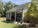 Covered patio with seating area, landscaping, and a fenced yard at 224 Melody Ln, Cameron, NC 28326