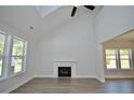 Spacious living room featuring a fireplace, large windows, and a vaulted ceiling, flooding the area with light at 2919 Lemuel Black Rd, Bunnlevel, NC 28323