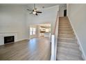 Bright, open-concept living space with a fireplace, staircase, and seamless flow into the kitchen at 2919 Lemuel Black Rd, Bunnlevel, NC 28323
