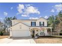 Charming two-story home with a front porch, two-car garage and landscaped yard under a blue sky at 511 Providence Hall Dr, Sanford, NC 27330