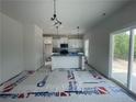 Open kitchen and dining area featuring white cabinets, modern appliances, and a sliding glass door at 24 Tackett Ct, Lillington, NC 27546