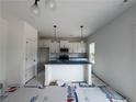 Bright kitchen featuring an island with a blue countertop, pendant lighting, and white cabinets at 24 Tackett Ct, Lillington, NC 27546