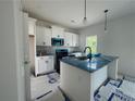 This kitchen has modern appliances, white cabinets, and an island with a sink and a view to the window at 24 Tackett Ct, Lillington, NC 27546