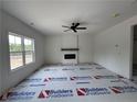 Cozy living room with a modern fireplace, ceiling fan, and a large window at 24 Tackett Ct, Lillington, NC 27546