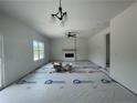 Bright living room featuring a fireplace, ceiling fan, and plenty of natural light from the window at 24 Tackett Ct, Lillington, NC 27546