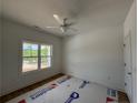 Bright bedroom with a ceiling fan, large window, and neutral walls, ready for your personal touch at 39 Tackett Ct, Lillington, NC 27546