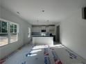Well-lit kitchen with white cabinets, center island and stainless steel microwave at 39 Tackett Ct, Lillington, NC 27546
