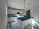 Modern kitchen features white cabinets, stainless steel appliances, and a center island with sink at 39 Tackett Ct, Lillington, NC 27546