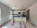 Bright kitchen with white cabinets, pendant lighting, and a central island perfect for food preparation at 39 Tackett Ct, Lillington, NC 27546
