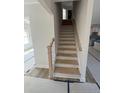 Bright, unfinished staircase features wood treads and light wood banister, waiting to connect the home's stories at 145 Surles Landing Way, Benson, NC 27504