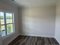 Bright room featuring wood-look flooring, fresh paint, and a large window at 23 Surles Landing Way, Benson, NC 27504