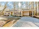 Brick ranch house with a gravel driveway and landscaping at 54 Red Holly Dr, Sanford, NC 27330