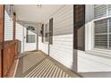 View of the front porch of a white house with wood railings and a storm door at 107 N 12Th St, Erwin, NC 28339