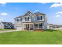 Inviting two-story home featuring a two-car garage, a cozy front porch, and a lush green lawn at 115 White Doe Xing, Cameron, NC 28326