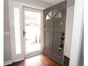 Open entryway featuring a modern front door with sidelight and dark hardwood flooring at 334 Brookfield Cir, Sanford, NC 27330