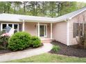 Inviting front entrance with a covered porch, brick walkway, and lush landscaping at 334 Brookfield Cir, Sanford, NC 27330