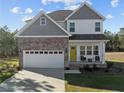 Beautiful two-story home with a brick-accented garage, a bright yellow door, and landscaped front yard at 501 Stadium Dr, Cameron, NC 28326