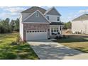 Inviting home features a spacious driveway, a two-car garage, and a cozy front porch area at 501 Stadium Dr, Cameron, NC 28326