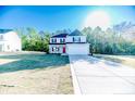 Two-story home with gray siding, black shutters, red door, spacious lawn and a long concrete driveway at 87 Onslow Ct, Spring Lake, NC 28390