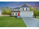 Beautiful two-story home with a bright red door, dark shutters, lush front lawn, and inviting curb appeal at 87 Onslow Ct, Spring Lake, NC 28390