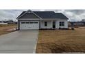 Attractive single-story home featuring a two-car garage and a manicured lawn at 135 Jones Creek Ln, Lillington, NC 27546